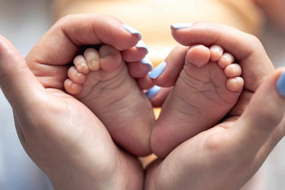 mom gently holding her baby's feet showing recovery from hand-foot-and- mouth disease
