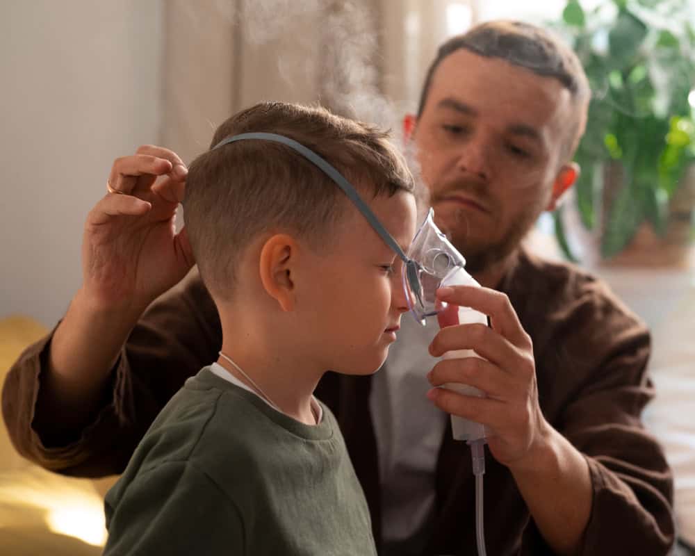 father giving son an asthma inhalation treatment